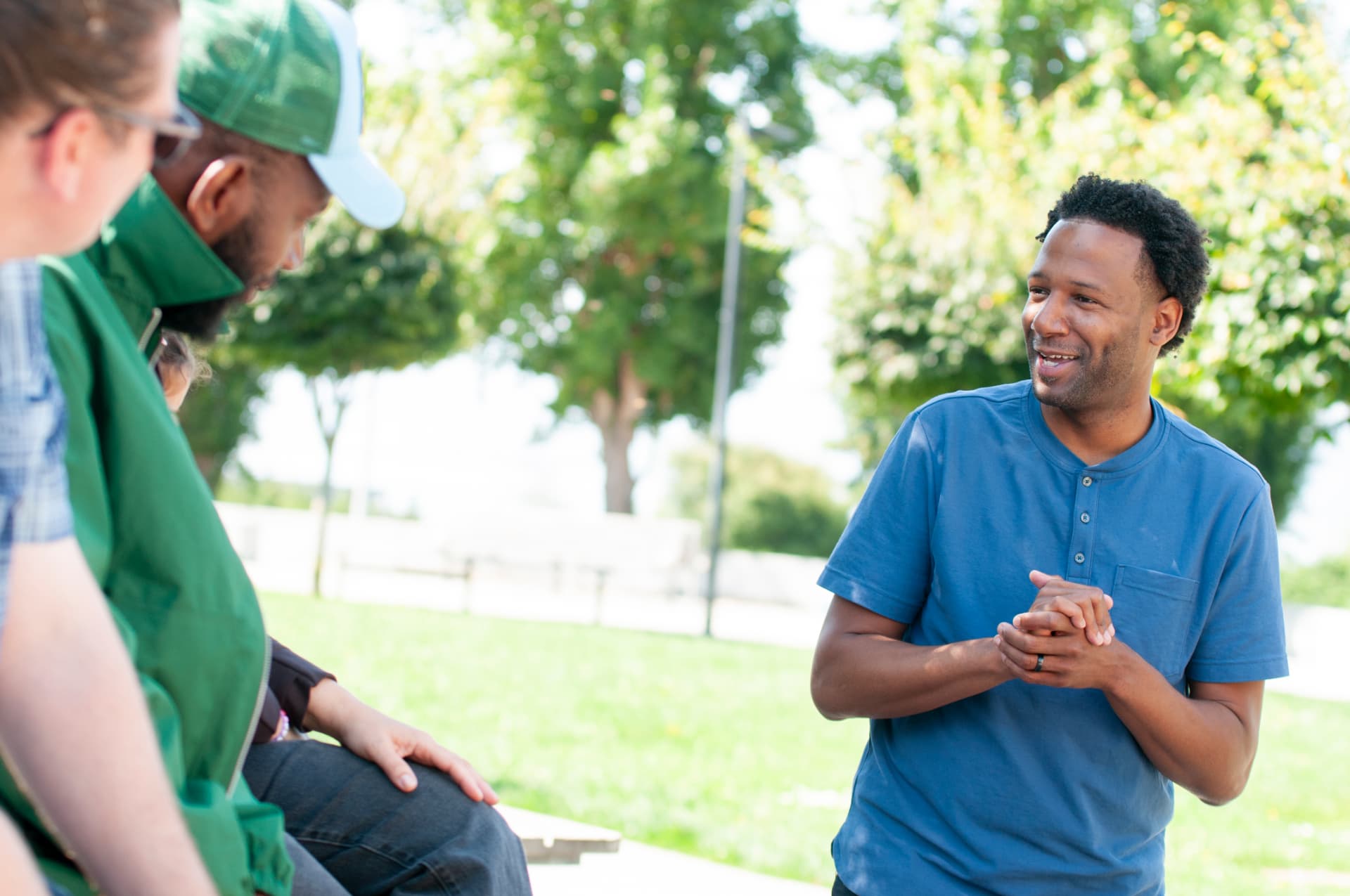 Theo Ellington smiling as he talks with neighbors in a park